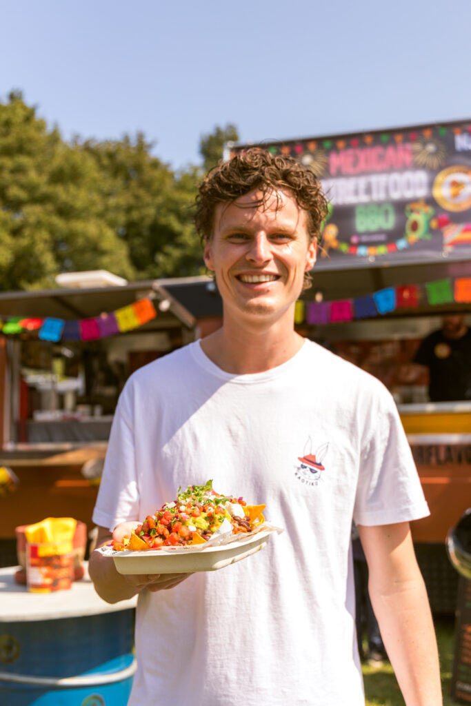 Op de foto zie je een gast die aan het genieten is van het eten van de Foodtruck BBQ van Porflavor Food