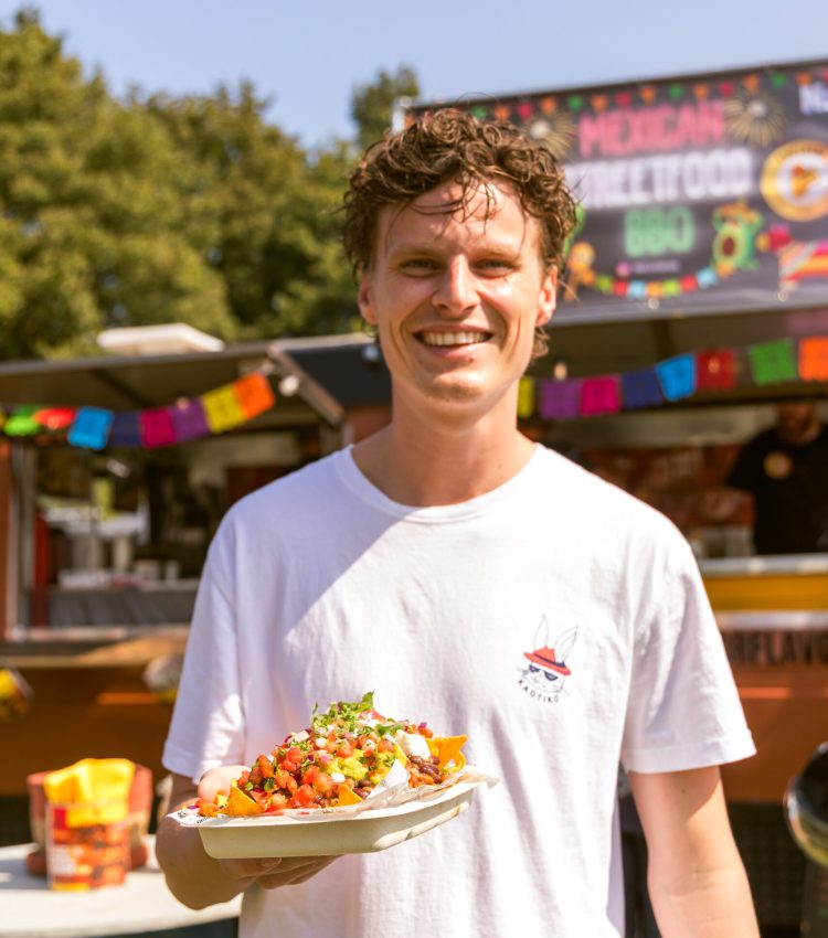 Op de foto zie je een gast die aan het genieten is van het eten van de Foodtruck BBQ van Porflavor Food